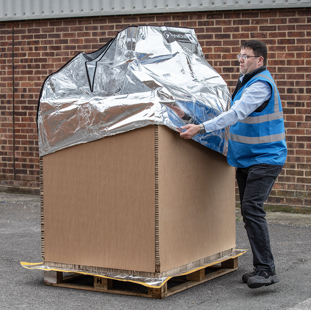 Foil pallet cover being placed on honeycomb pallet container